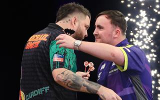 Luke Littler and Michael Smith embrace after their Premier League semi-final in Cardiff