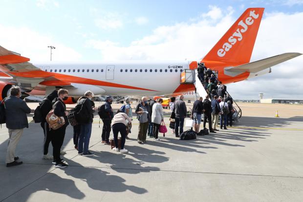 Runcorn and Widnes World: People queue to board an EasyJet plane. (PA)